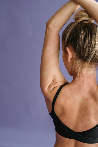 Woman stretching with her hands above her head