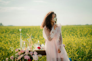 Woman In Flower Field Smelling Flower