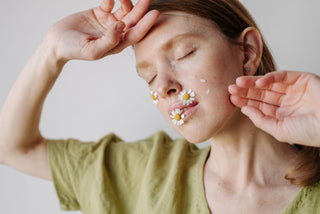 Creative portrait of a woman with daisies on her face