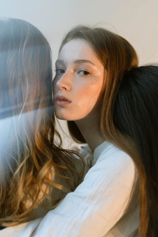 Three women embrace softly, reflecting deep connection and empathy