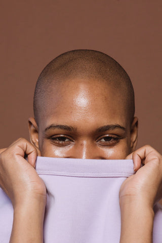 Woman holding t-shirt over her mouth