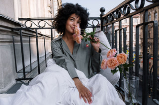 Woman smelling roses on a balcony