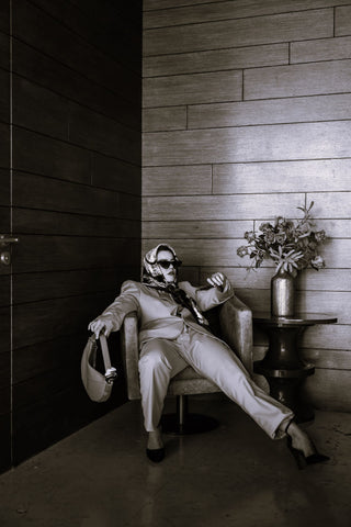 High-fashion person in a suit lounging in a chair