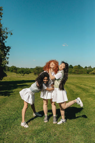 Friends Standing on a Green Grass Field