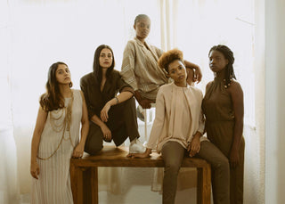 Women sitting on a brown wooden bench