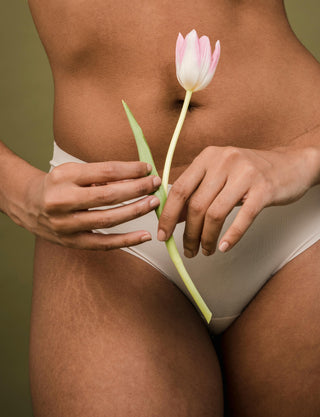 Unrecognizable woman with principles of body positive holding fresh flower in hands
