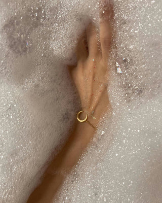 Hand with bracelet in bath foam