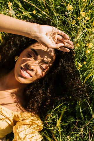 Woman lying in grass in the sunshine
